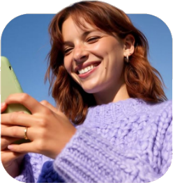 Mujer sonriendo mientras mira su teléfono